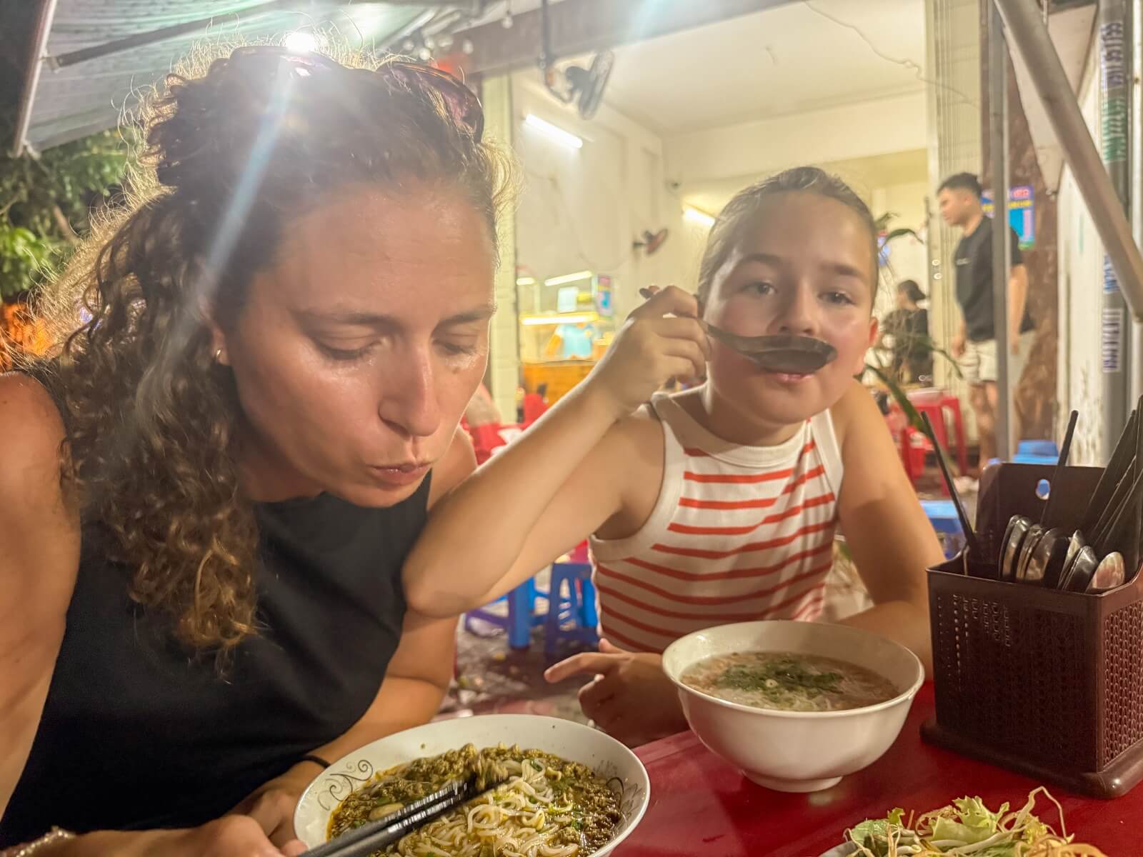 Sévérine en Ida eten Bun Ram en Bun Tom aan een straattafeltje