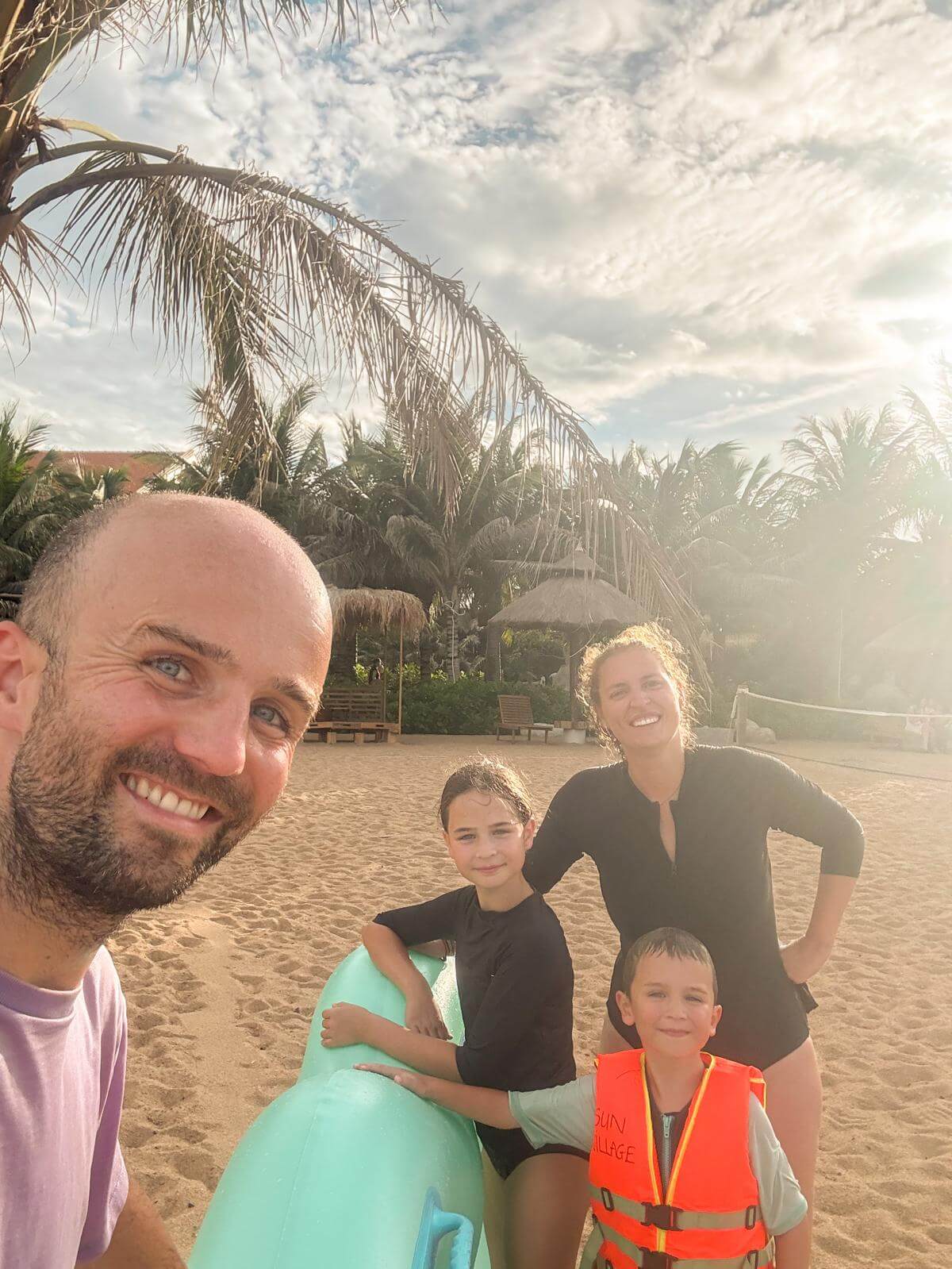 Gezinsselfie op het strand bij zonsondergang na een dip in zee
