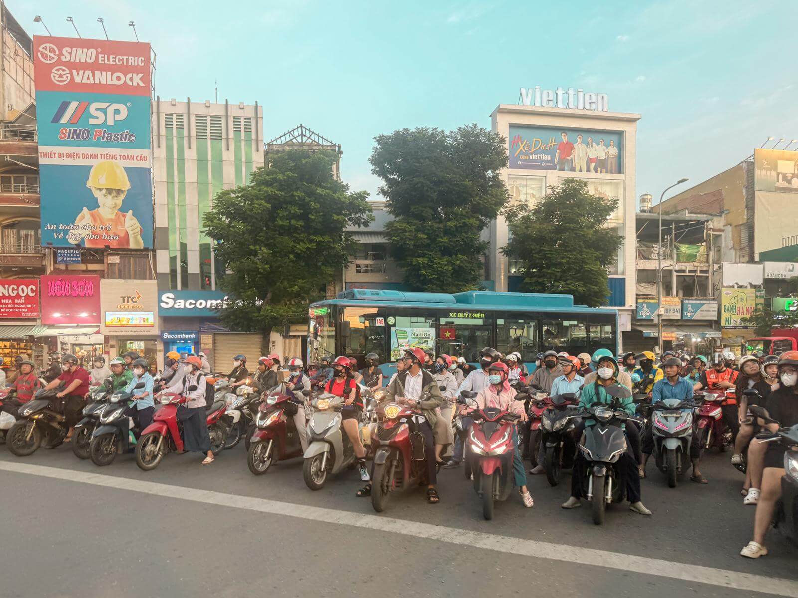Een drukke kruising vol scooters en brommers in het spitsuur van Ho Chi Minh City