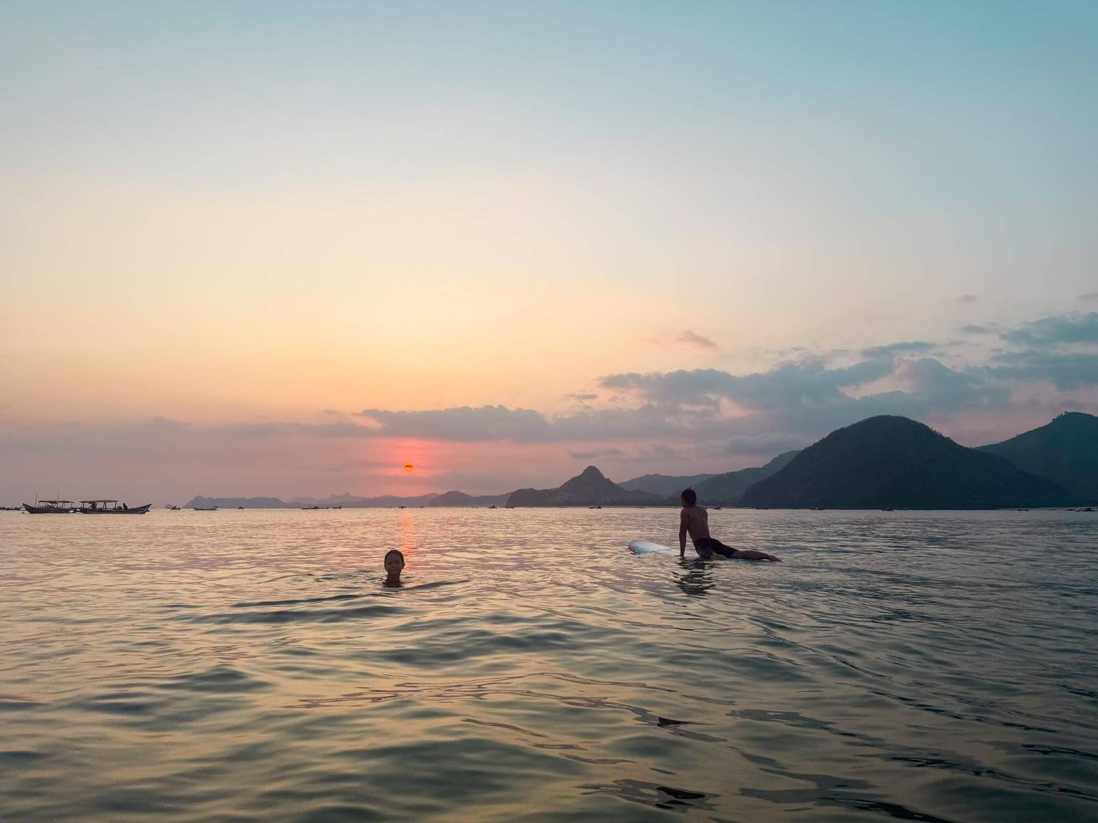 Op de surfplank wachten op de zonsondergang